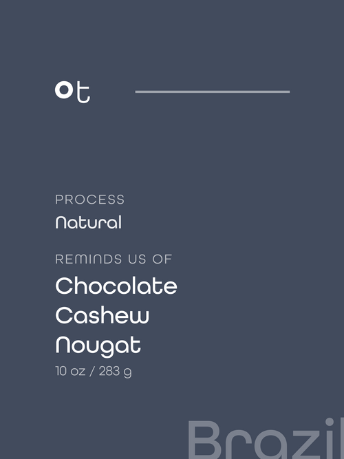 Dark slate blue package label with white text reading 'ot', 'PROCESS Natural', 'REMINDS US OF Chocolate Cashew Nougat', and '10 oz / 283 g'. A faint 'Brazil' watermark appears at the bottom right.